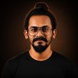 Professional portrait of Arun TR, a product designer and digital marketer in Thrissur, wearing glasses, a mustache, and a beard